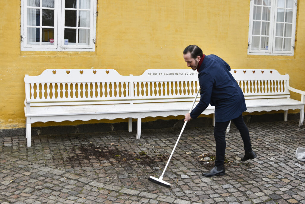 Formanden for menighedsrådet igang med kosten.